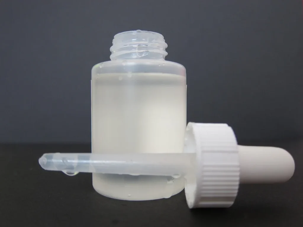 Frasco con cuentagotas de sérum facial con ácidos exfoliantes para la rutina de noche